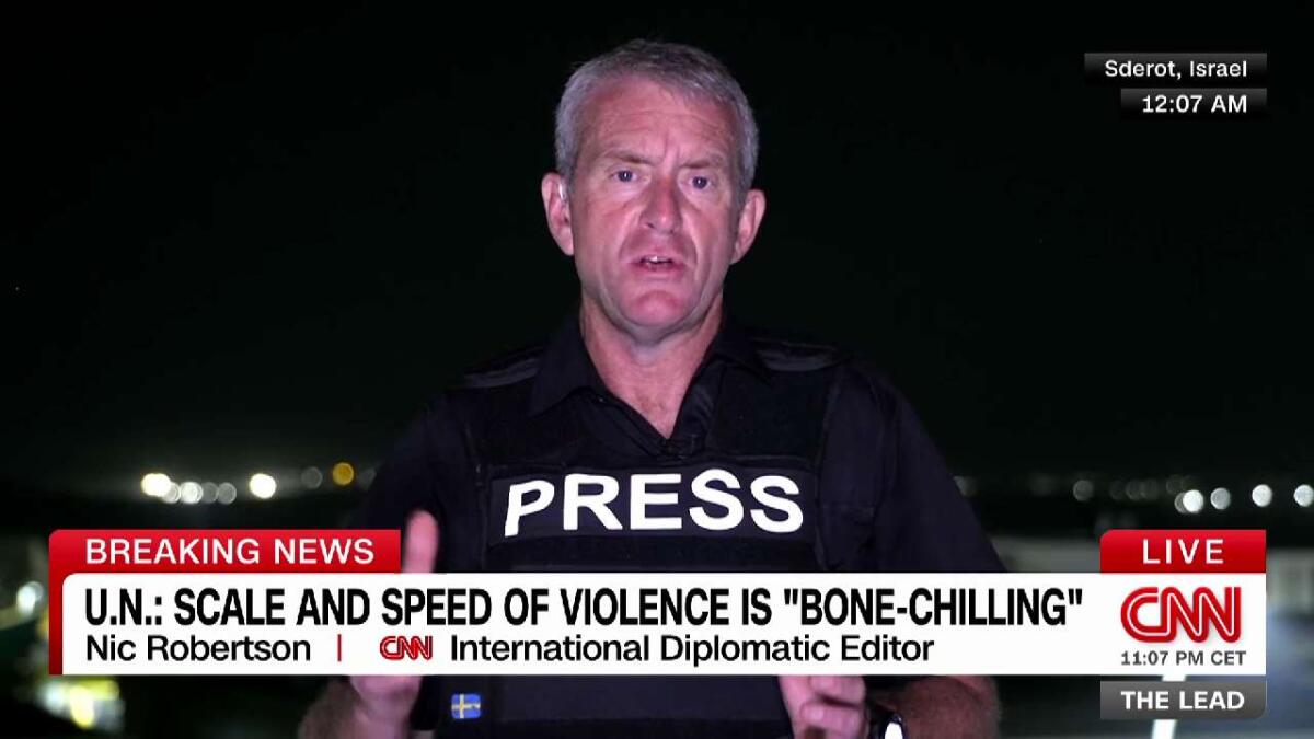 A man wearing a sign that says Press reports on CNN.