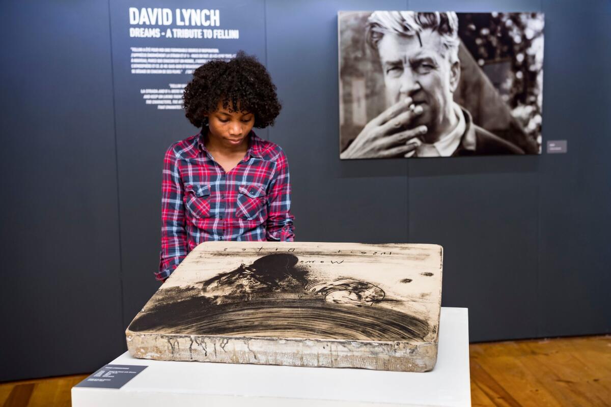 A visitor at the Maison du Diable in Sion, Switzerland, looks at artwork by David Lynch in the exhibition "David Lynch: Dreams — A Tribute to Fellini," on view through Dec. 16.