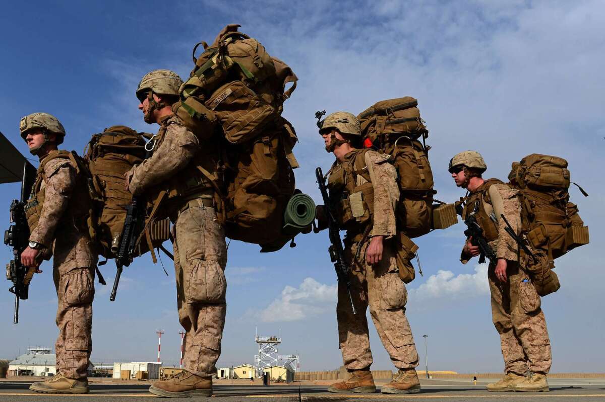 U.S. Marines board a transport aircraft headed to Kandahar as British and U.S. forces withdraw from the Camp Bastion-Leatherneck complex in Helmand province on October 27, 2014.