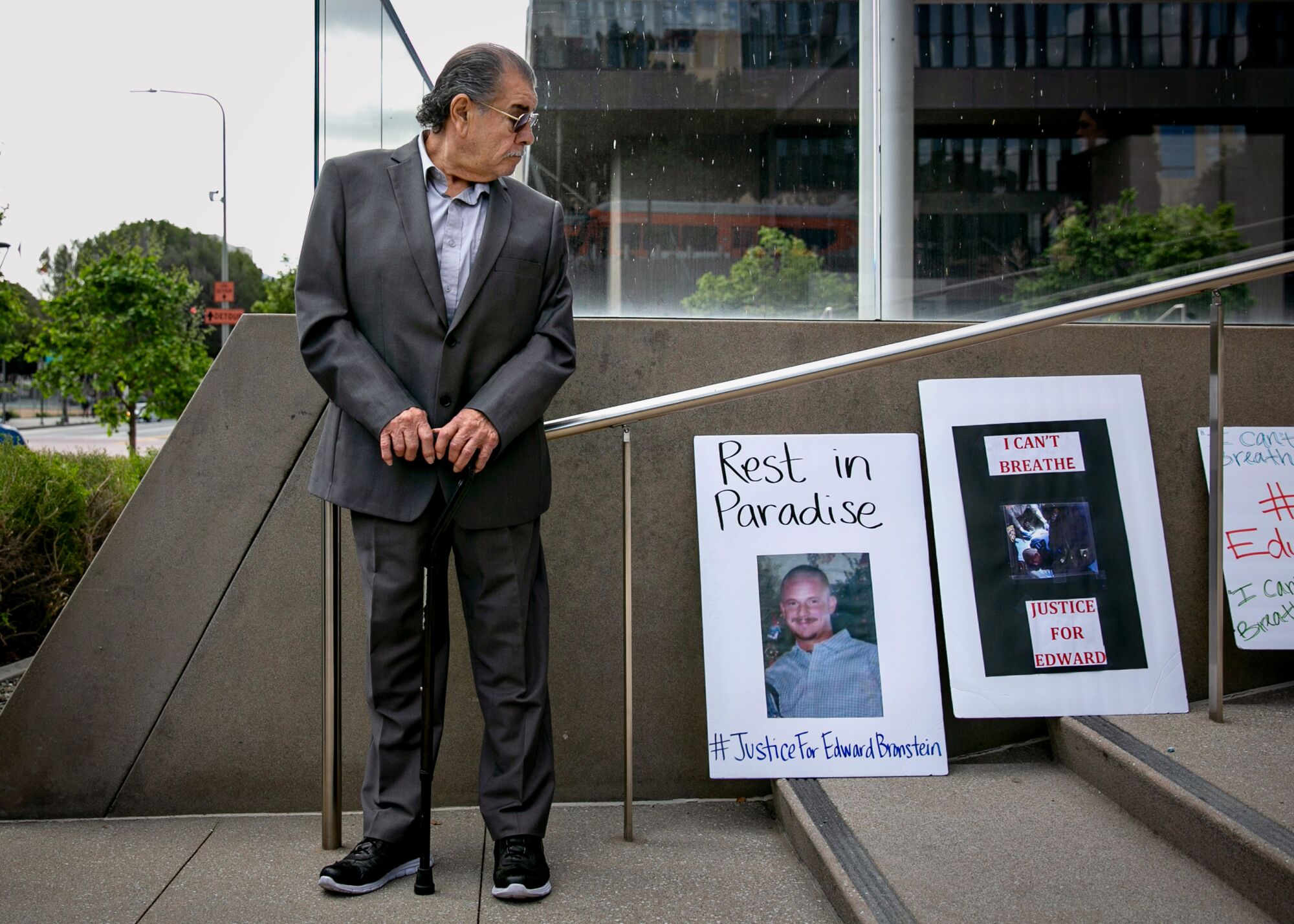 A man in a suit looking down at posters on an outdoor stairway 