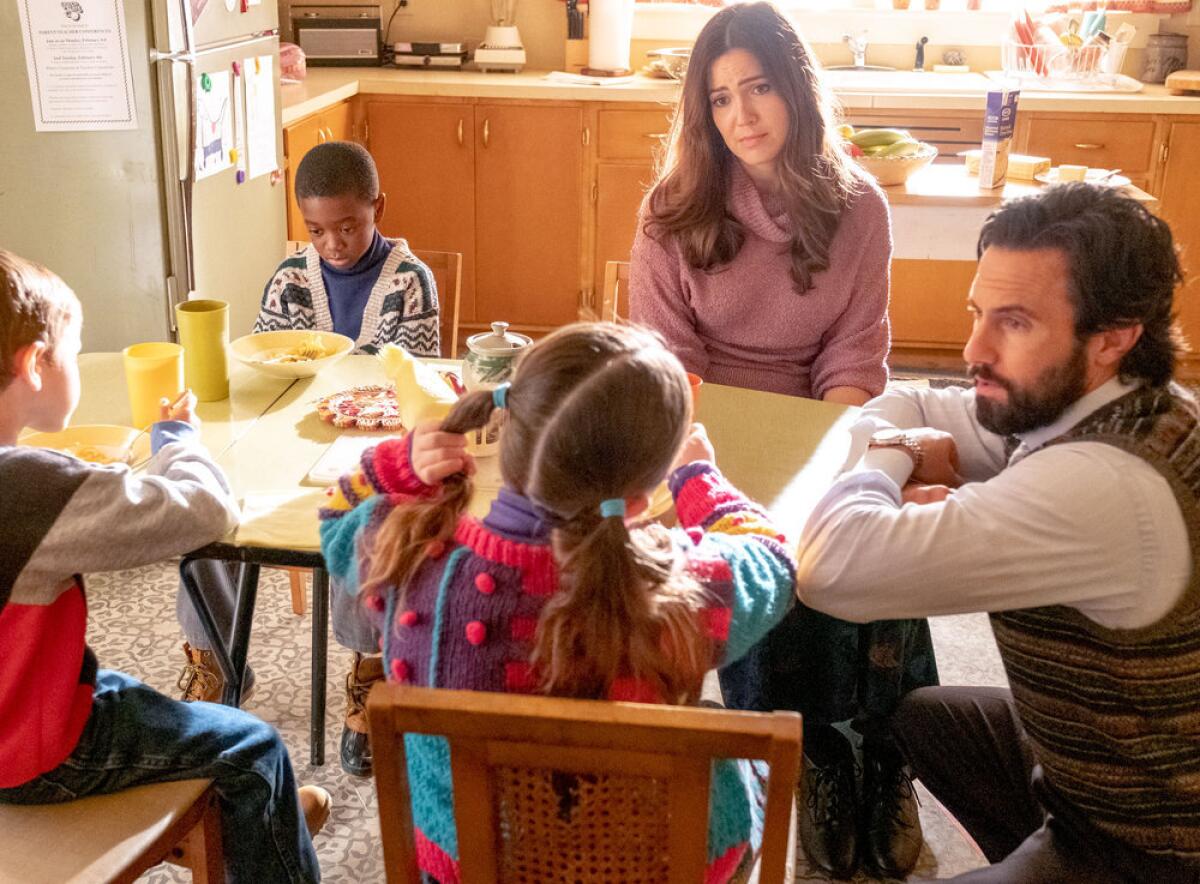 Two parents sitting at the table with their young children