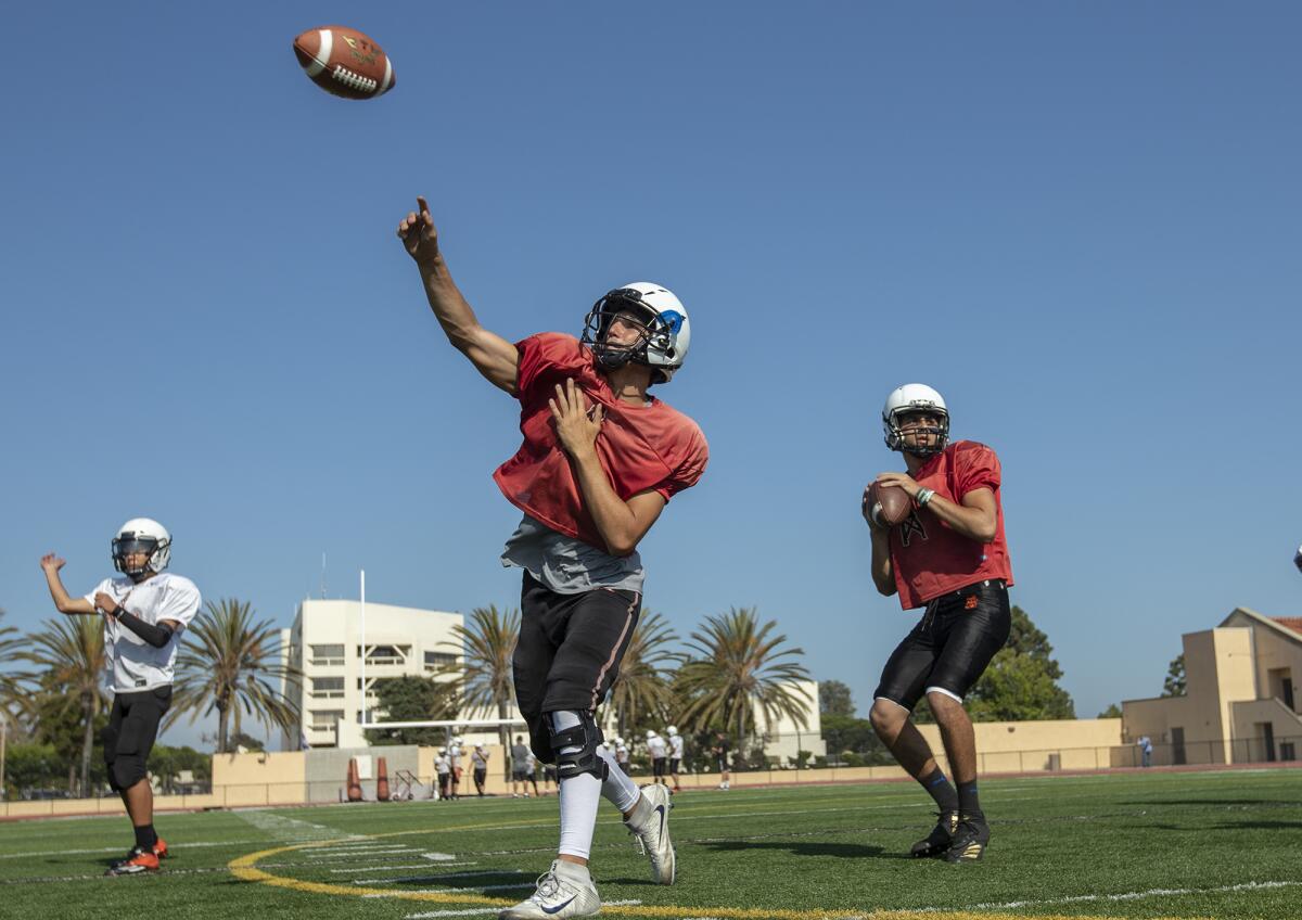 Brady Gardner, left, and Brandon Cannella run through passing drills during Huntington Beach's practice at Cap Sheue Field on Aug. 7.
