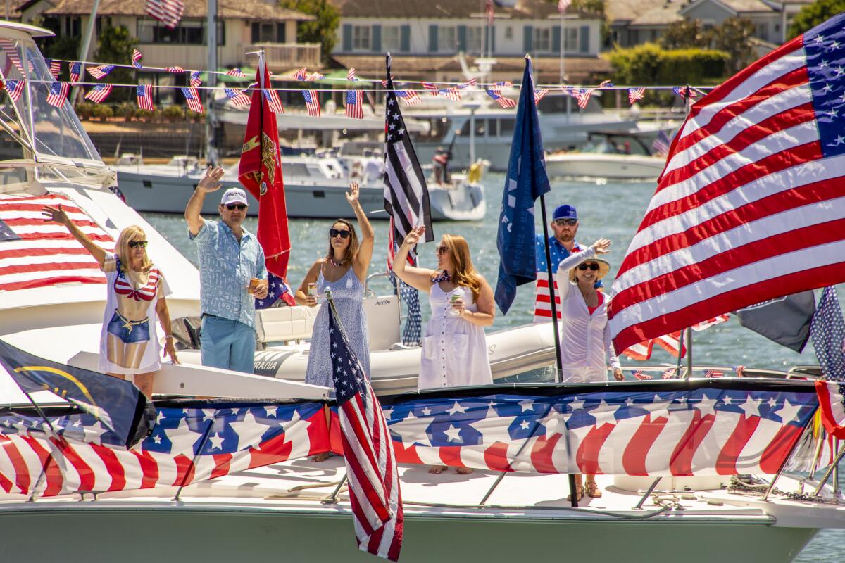 Flags and waves on the foredeck of My Way in the Old Glory Boat Parade at Newport Harbor in 2021.