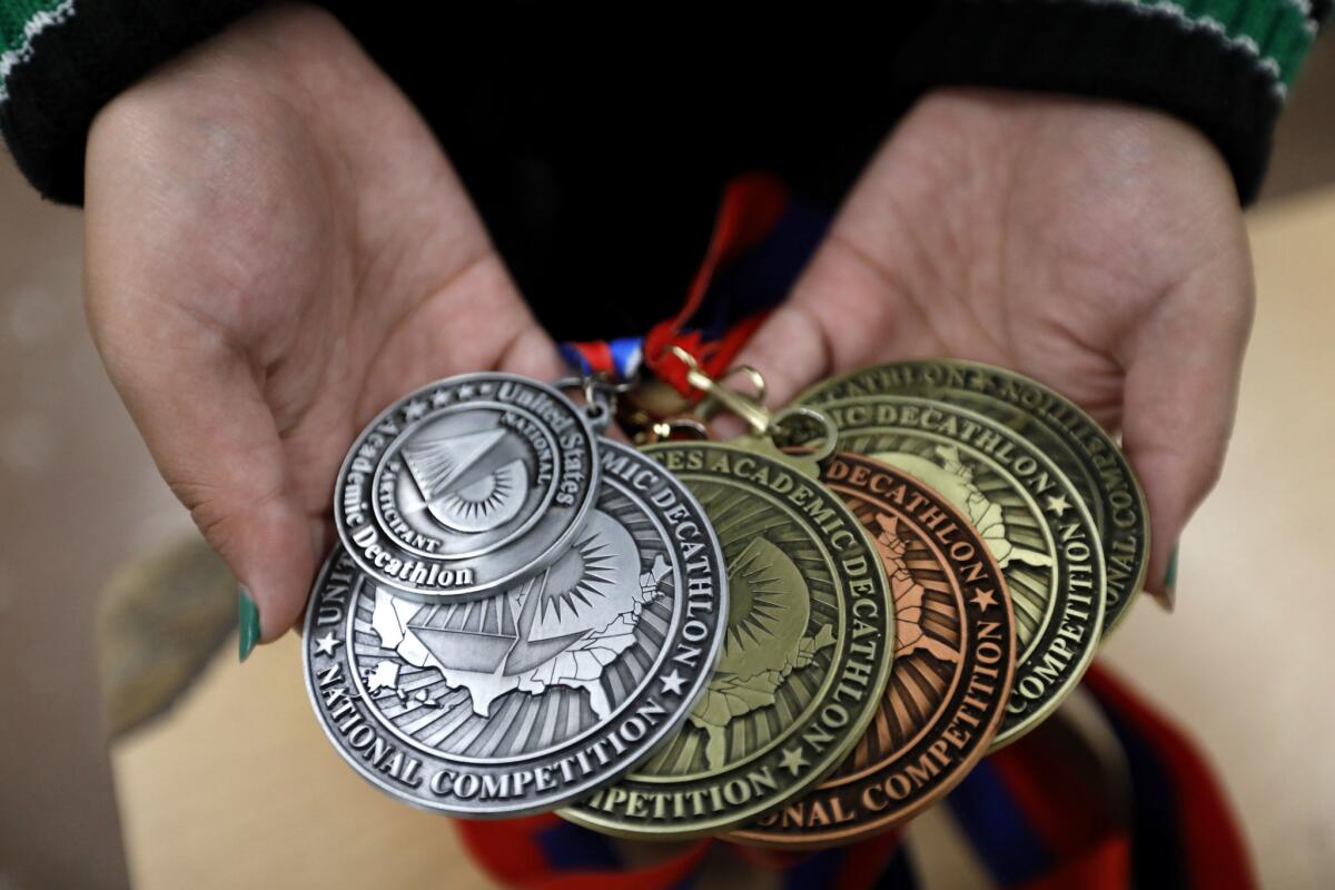 Tamara Cruz shows a few of the nine medals she won at the U.S. Academic Decathlon in Bloomington, Minn.
