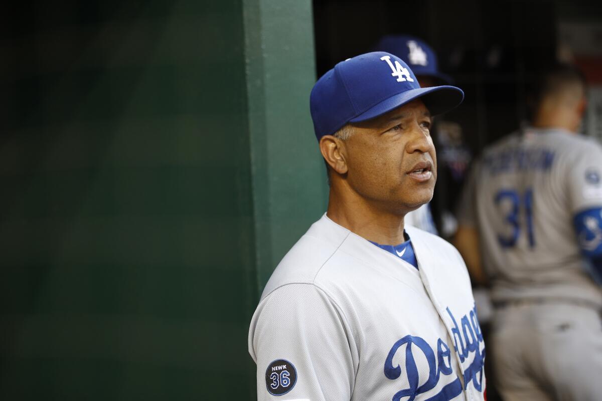 Dodgers manager Dave Roberts stands in the dugout.