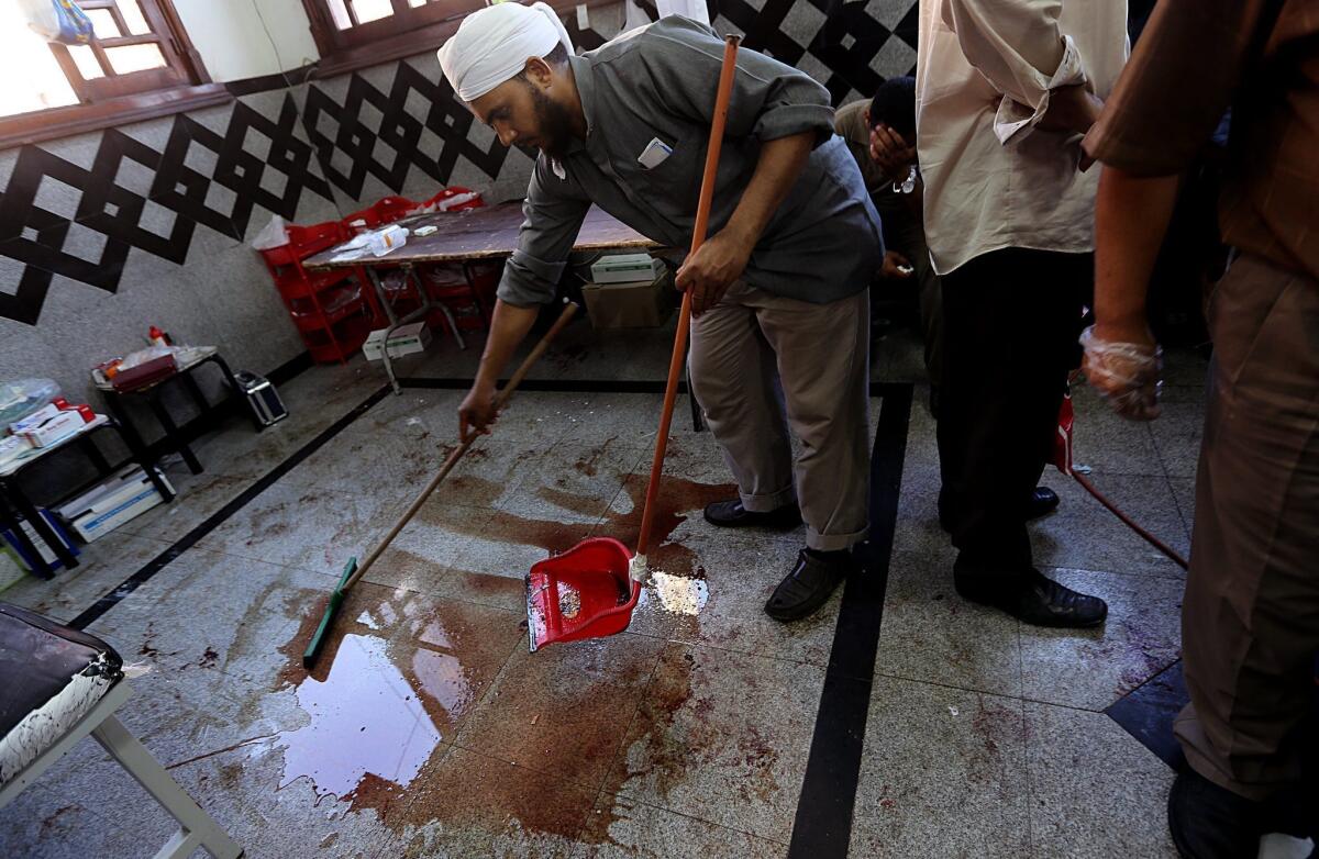A man cleans blood from a makeshift hospital after dozens were killed in clashes between supporters of Egypt's ousted president, Mohamed Morsi, and security forces in Cairo.