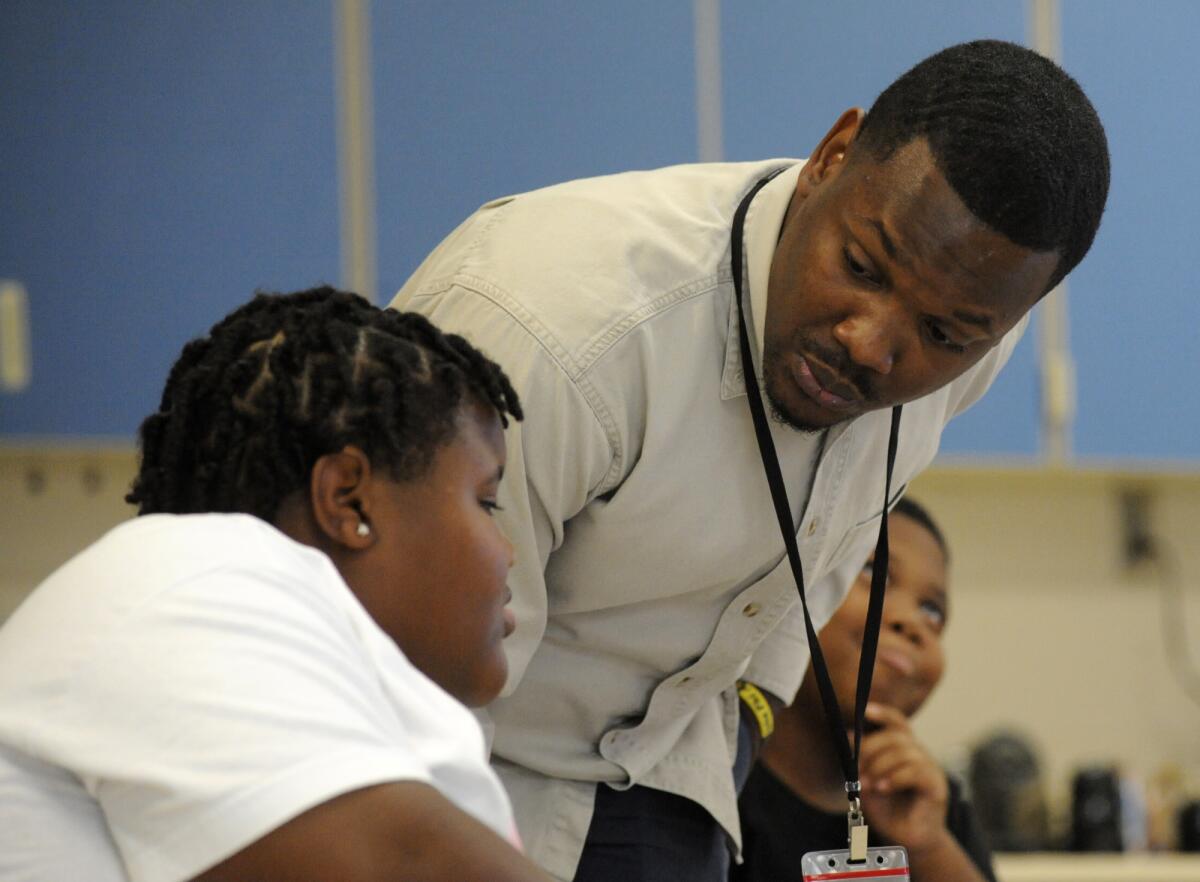A teacher in Birmingham, Ala., works with elementary school students