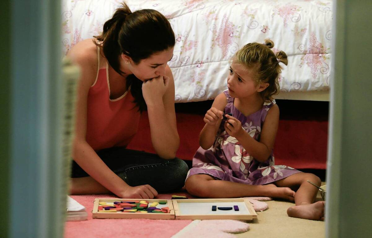 Six-year-old Naia Sullivan receives autism therapy in the bedroom of her home in San Diego from Hali Curry, a behavioral therapist. Naia's father said she had benefited greatly from applied behavior analysis, a treatment that will no longer be covered by the state.