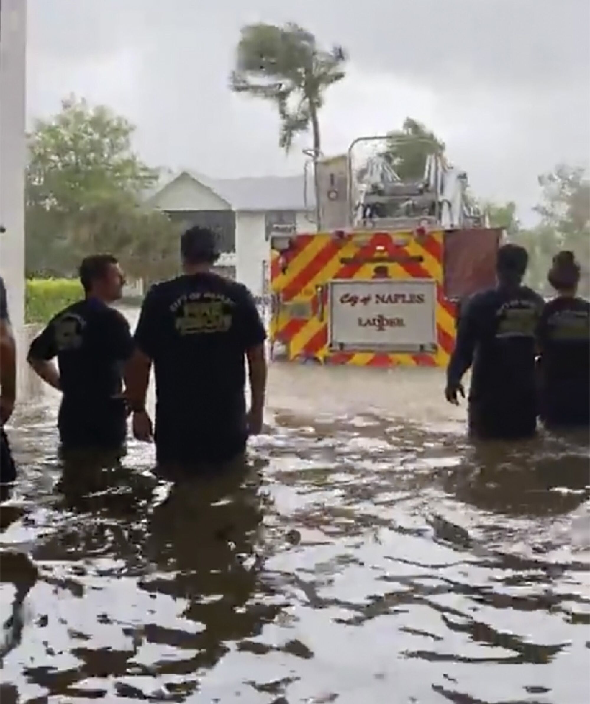 Firefighters look out at firetruck submerged in flood waters from Hurricane Ian. 