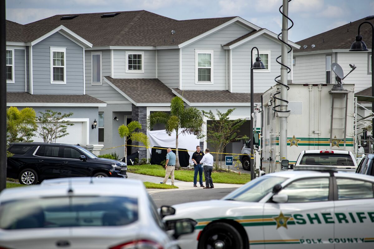 Polk County Sheriff's investigators work the scene where three workers were attacked, Saturday, Oct. 2, 2021, in Davenport, Fla. Polk County Sheriff's officials said Shaun Runyon, wielding a knife and baseball bat, killed three co-workers and injured another at the Florida home they shared. (Ernst Peters/The Ledger via AP)