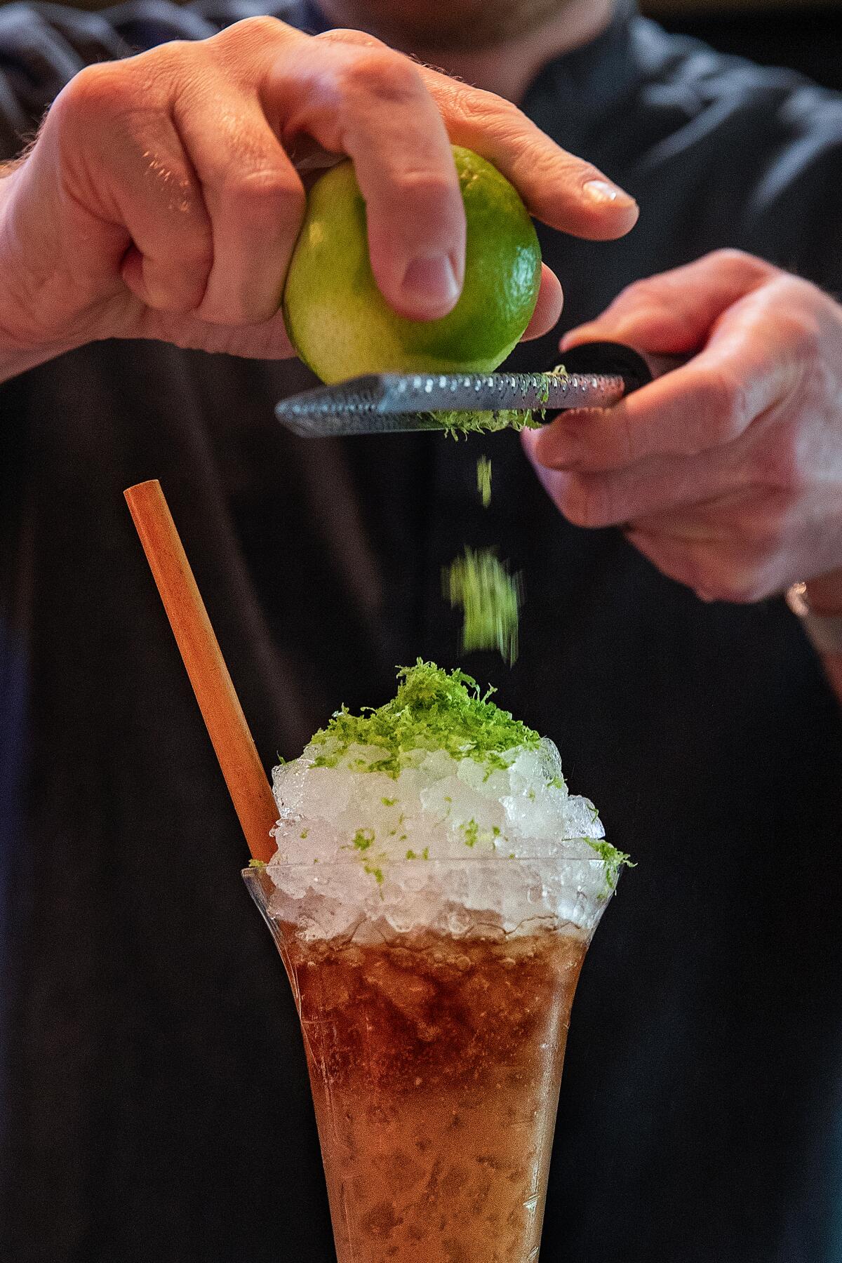 Austin Hennelly adds grated lime to an Amazake Swizzle.