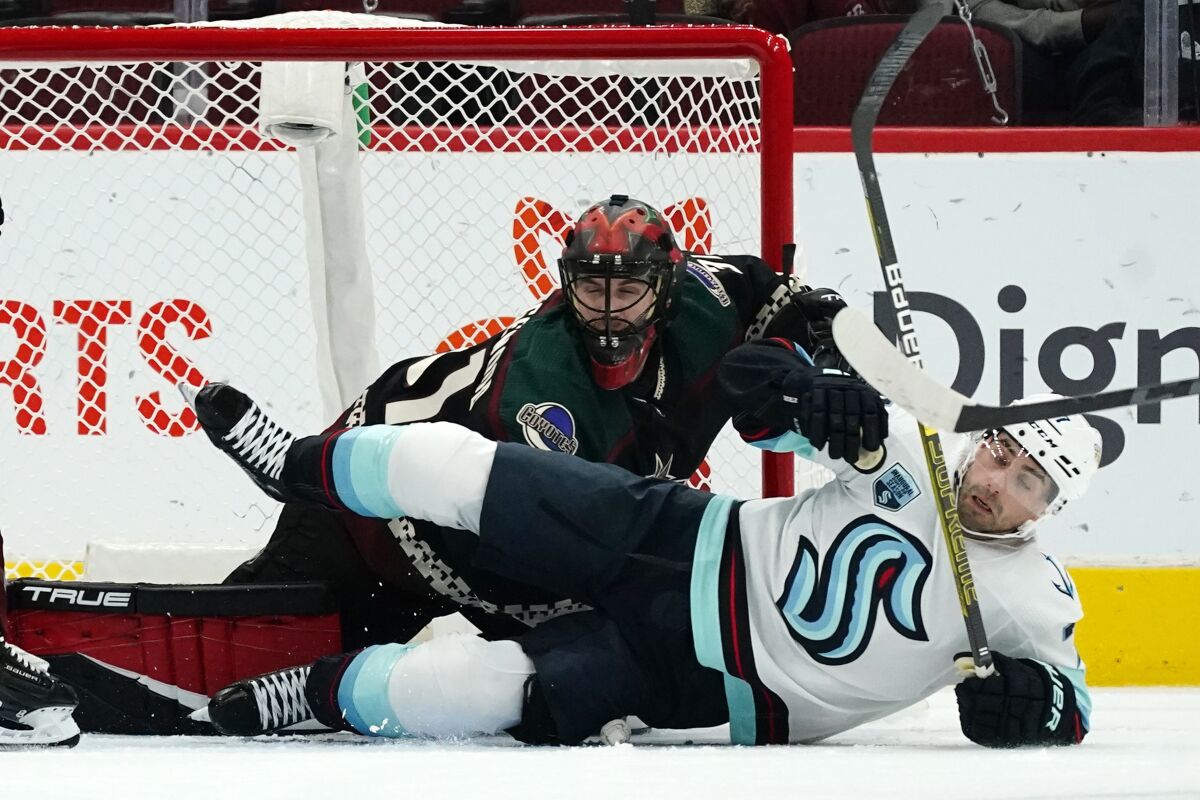 Seattle Kraken right wing Jordan Eberle, right, falls to the ice over Arizona Coyotes goalie Scott Wedgewood, left, during the first period of an NHL hockey game Saturday, Nov. 6, 2021, in Glendale, Ariz. (AP Photo/Ross D. Franklin)