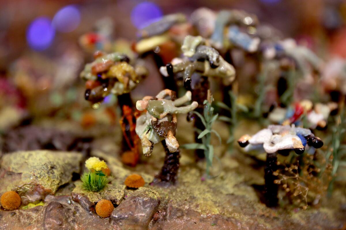 Melted figurines on trees in a model landscape