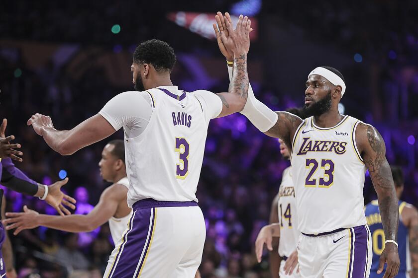 LOS ANGELES, CA, WEDNESDAY, OCTOBER 16, 2019 - Los Angeles Lakers forward LeBron James (23) and Anthony Davis (3) high five during a break in the action against the Golden State Warriors in a preseason game at Staples Center. (Robert Gauthier/Los Angeles Times)