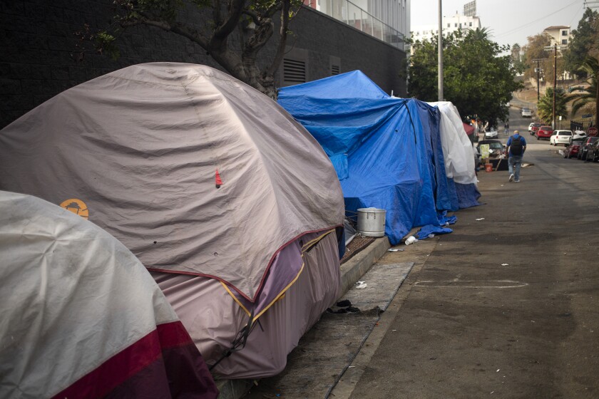 Las tiendas de campaña se alinean en la acera de un campamento de personas sin hogar