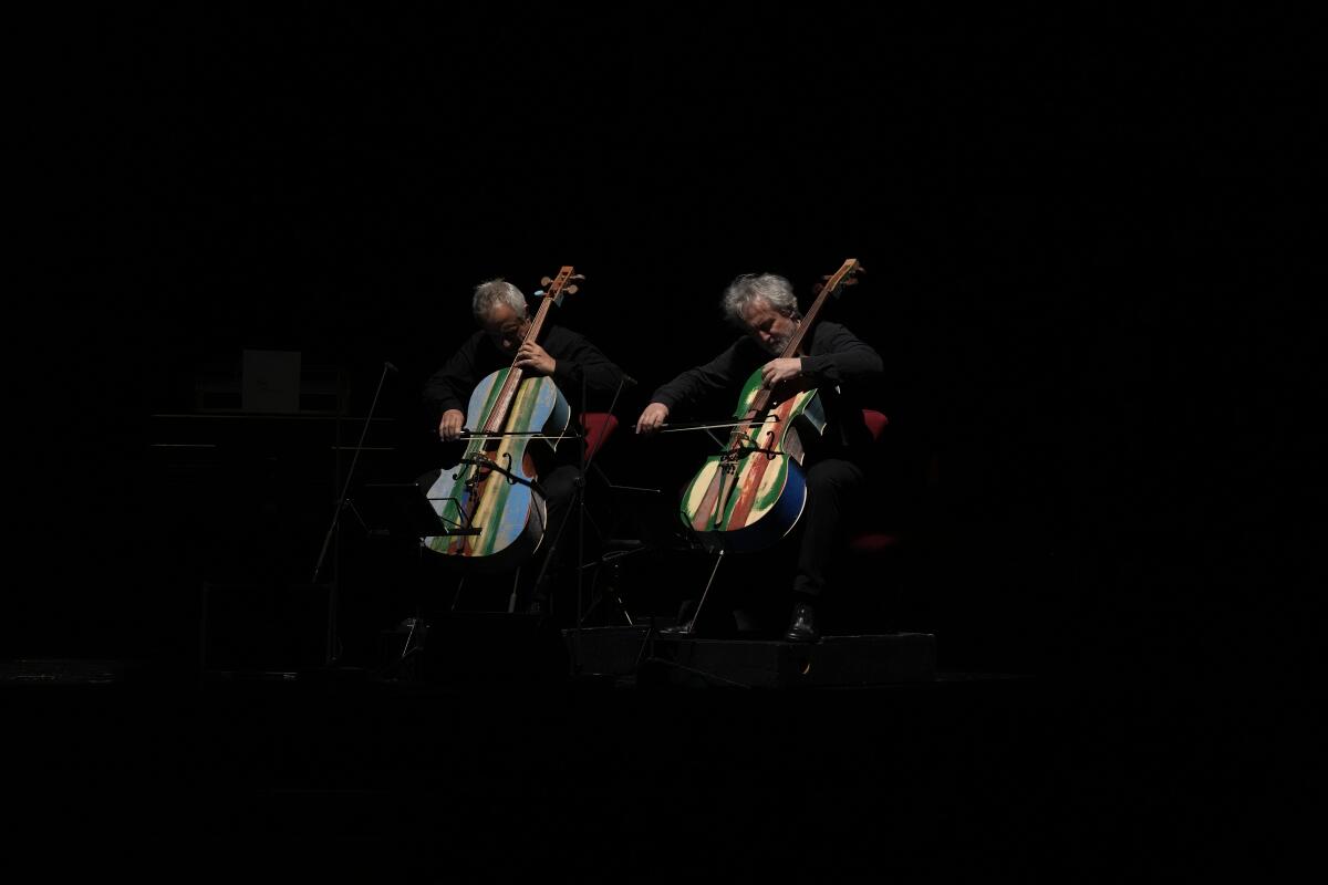 Miembros de la Orquesta del Mar tocan cellos fabricados con madera de barcos de inmigrantes en Milán, Italia
