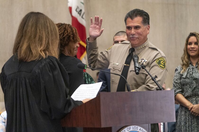 New Los Angeles County Sheriff Robert Luna is sworn in by the Honorable Samantha Jersey, Presiding Judge-elect of the Superior Court of Los Angeles County, far left, in Los Angeles, Saturday, Dec. 3, 2022. Luna takes charge after the turbulent single term of former Sheriff Alex Villanueva, whose tenure was marked by clashes with members of the LA County Board of Supervisors and allegations that he downplayed accusations that gang-like groups of deputies ran amok within the agency. (AP Photo/Damian Dovarganes)