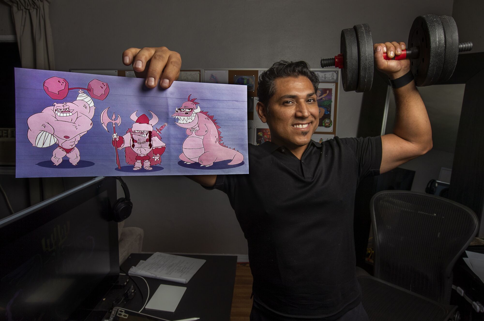 Artist Jose Zelaya holds up a portfolio piece. Zelaya has worked for Disney since 1997.