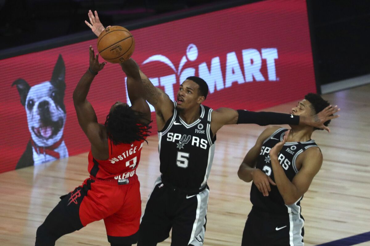 San Antonio Spurs guard Dejounte Murray (5) defends against Houston Rockets guard Chris Clemons (3) during the second of an NBA basketball game Tuesday, Aug. 11, 2020, in Lake Buena Vista, Fla. (Kim Klement/Pool Photo via AP)