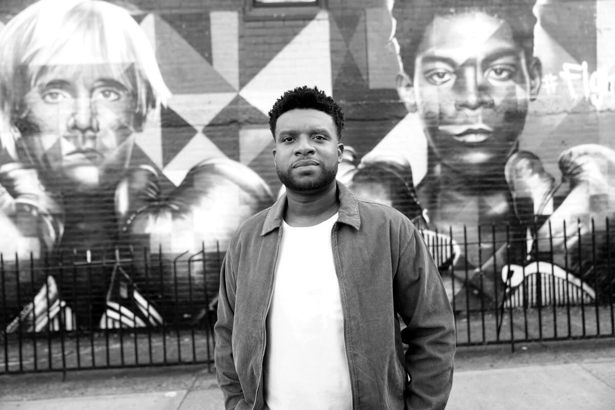 Playwright Keenan Scott II with "Blessed Brooklyn With a Colorful Mural of Basquiat and Andy Warhol" by Eduardo Kobra.