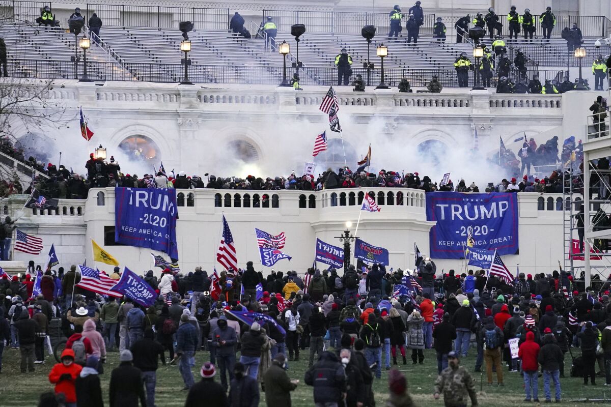 FILE - Violent insurrectionists, loyal to President Donald Trump, storm the Capitol in Washington on Jan. 6, 2021. The first trial for one of the hundreds of Capitol riot prosecutions starts this week, with jury selection scheduled to begin on Monday, Feb. 28, 2022, for the case against Guy Wesley Reffitt. (AP Photo/John Minchillo, File)
