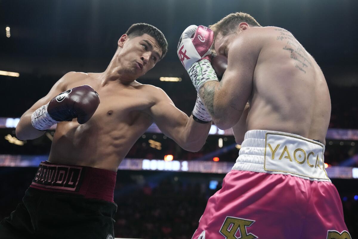 Dmitry Bivol, left, throws a punch against Canelo Álvarez during the first round Saturday.