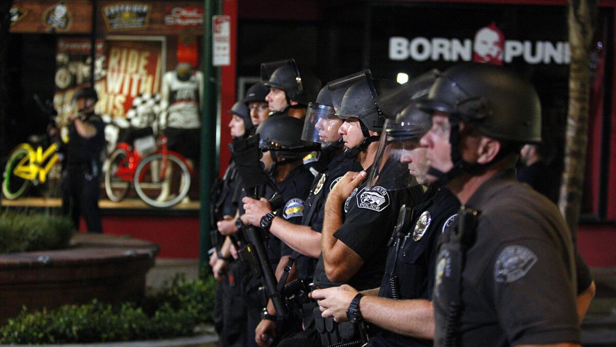 Police confront rioters in Huntington Beach after the U.S. Open of Surfing finals in 2013 — the only riots to take place in the area recently, contrary to President Trump's claims of riots against California's "sanctuary" law.