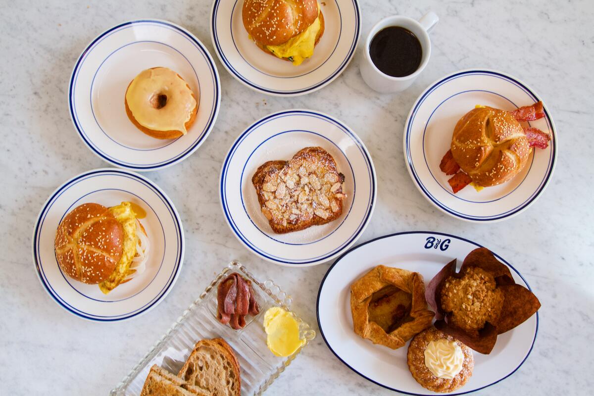 An overhead photo of breakfast sandwiches, toast and pastries from Bub and Grandma's spread across a marble tabletop.