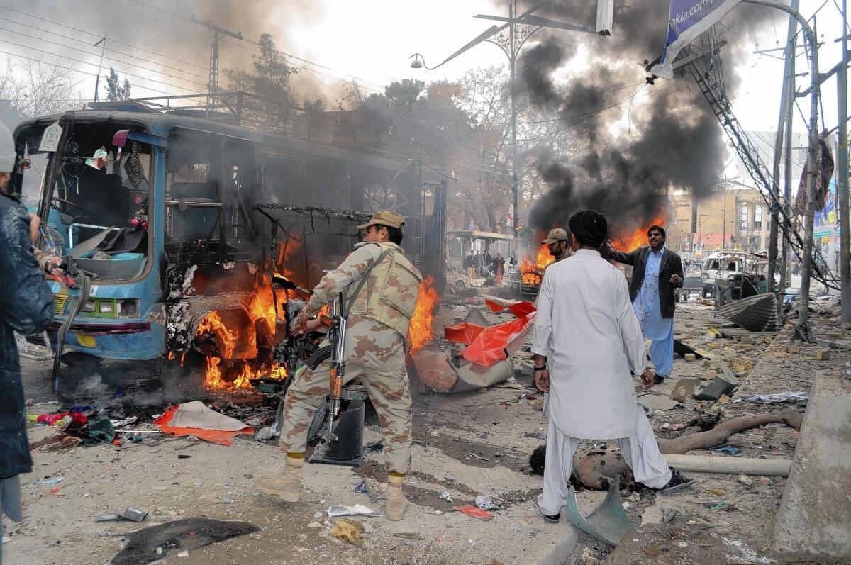 Pakistani paramilitary soldiers and passersby at the site of a bombing in Quetta.