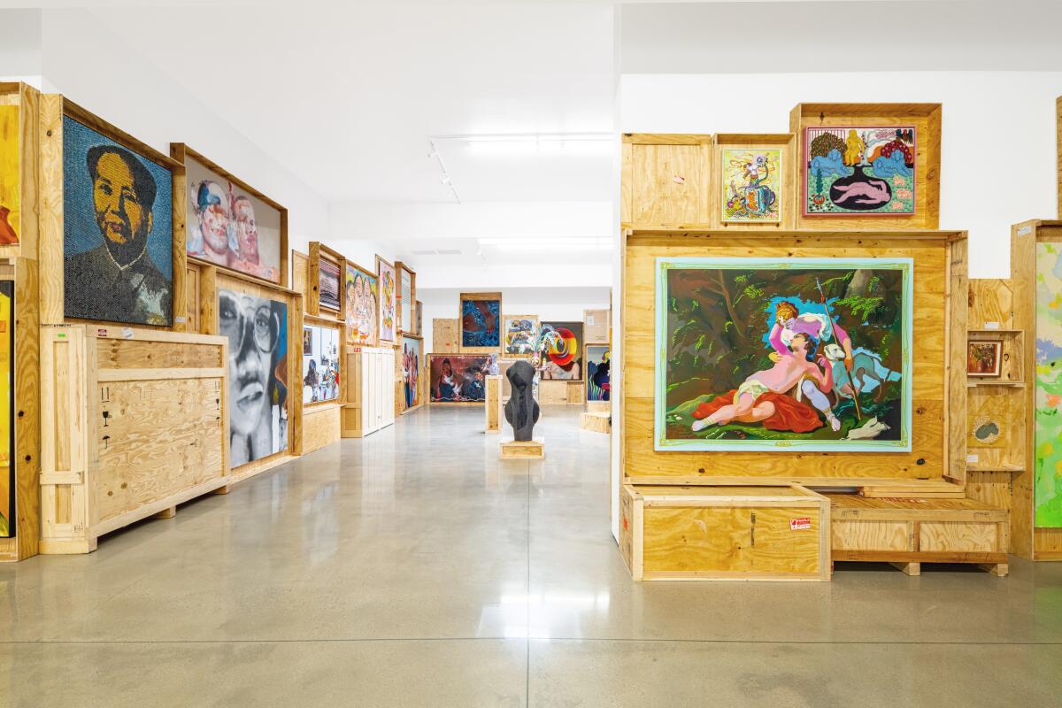 Paintings displayed in wooden crates. 