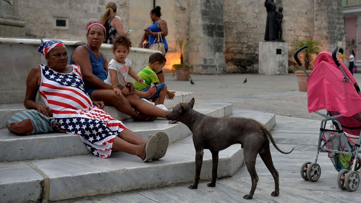 A woman wearing a dress with a U.S. flag design rests at a square in Havana on May 6.