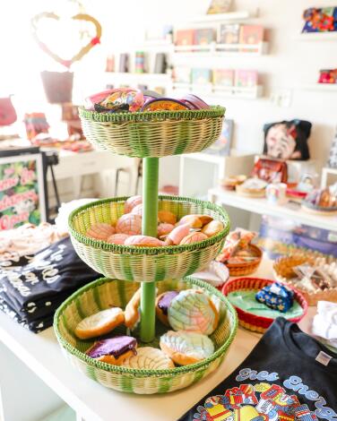 A three-tiered basket of colorful items on display among others at a store.