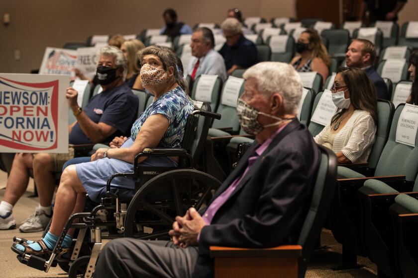 RIVERSIDE, CALIFORNIA - MAY 8, 2020: Residents who want public health orders rescinded attend an emergency meeting of the Riverside County Board of Supervisors at the County Administrative Center in the midst of the ongoing coronavirus pandemic on May 8, 2020 in Riverside, California. Type written notes are placed on chairs to keep people from sitting near each other. (Gina Ferazzi/Los Angeles Times)