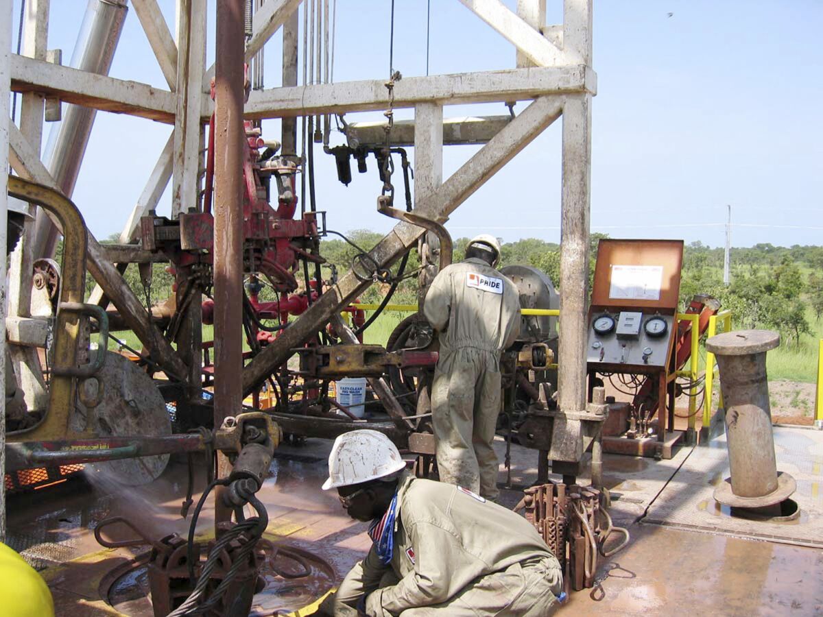 FILE —Chadian workers guide a pipe down a well in the Doba oil fields in southern Chad Oct. 10, 2003. Chad is nationalizing all assets from oil giant Exon Mobil, including hydrocarbon and exploration permits, said Haliki Choua Mahamat the government's general secretary on state media Thursday March 23, 2023. (AP Photo/Susan Linnee, File)