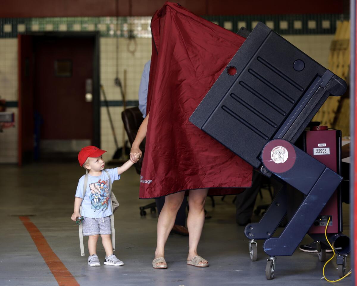 James Percella, 2, holds his mother's hand as she steps into a voting booth in Hoboken, N.J., on June 7.