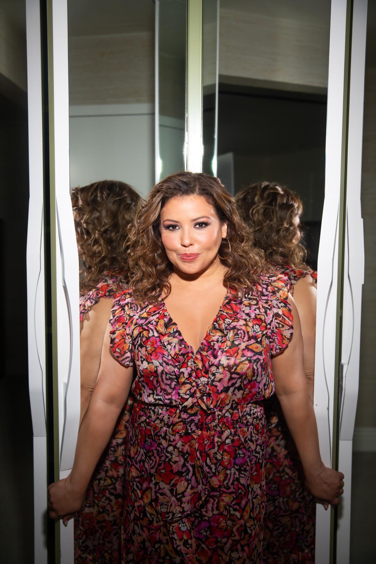 Actor Justina Machado poses in front of a mirror.