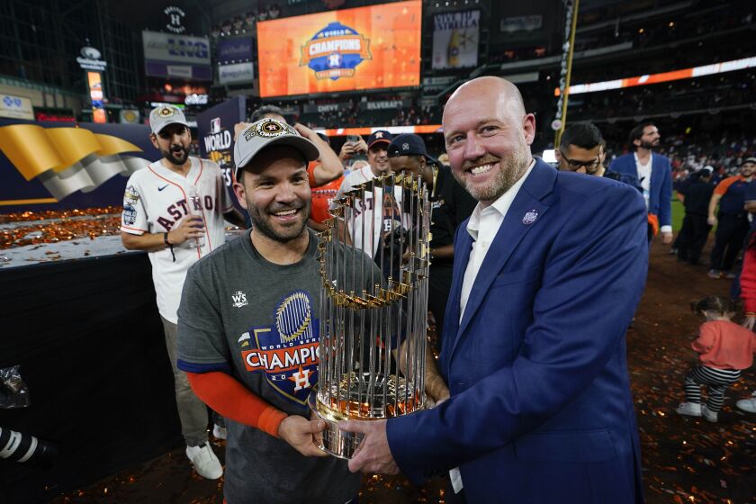 El intermedista venezolano José Altuve y el gerente general James Click, de los Astros de Houston, festejan con el trofeo de la Serie Mundial, el sábado 5 de noviembre de 2022 (AP Foto/David J. Phillip)