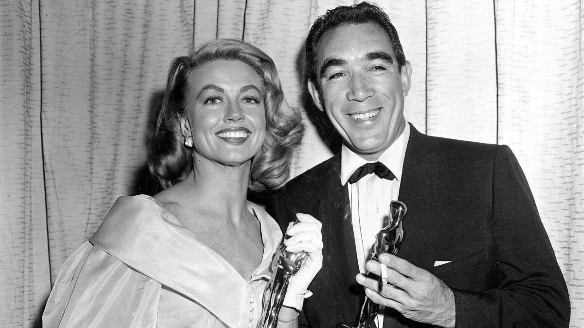 Best supporting Oscar winners Dorothy Malone and Anthony Quinn pose at the Academy Awards.