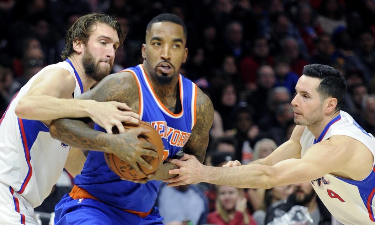 Knicks guard J.R. Smith tries to drive between Clippers forward Spencer Hawes, left, and guard J.J. Redick.