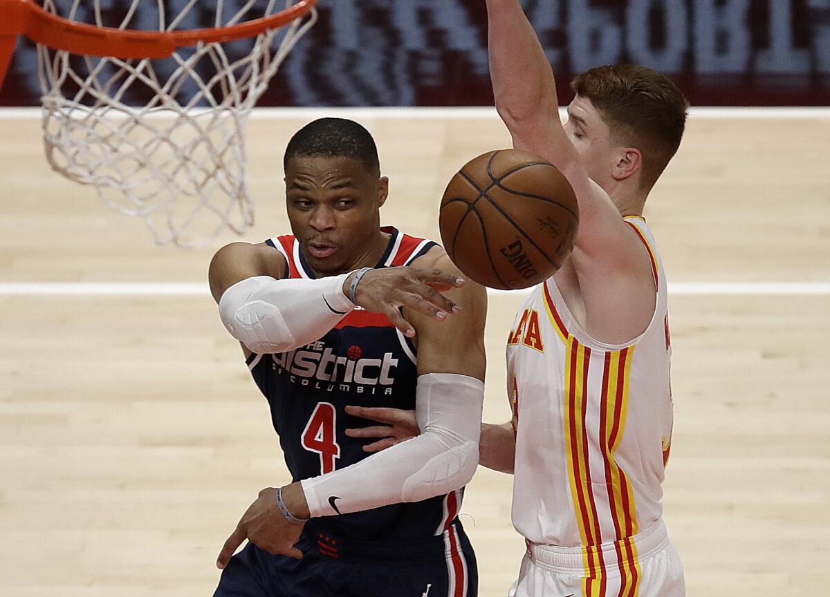Washington Wizards' Russell Westbrook, left, passes away from Atlanta Hawks' Kevin Huerter in the second half of an NBA basketball game Monday, May 10, 2021, in Atlanta. (AP Photo/Ben Margot)