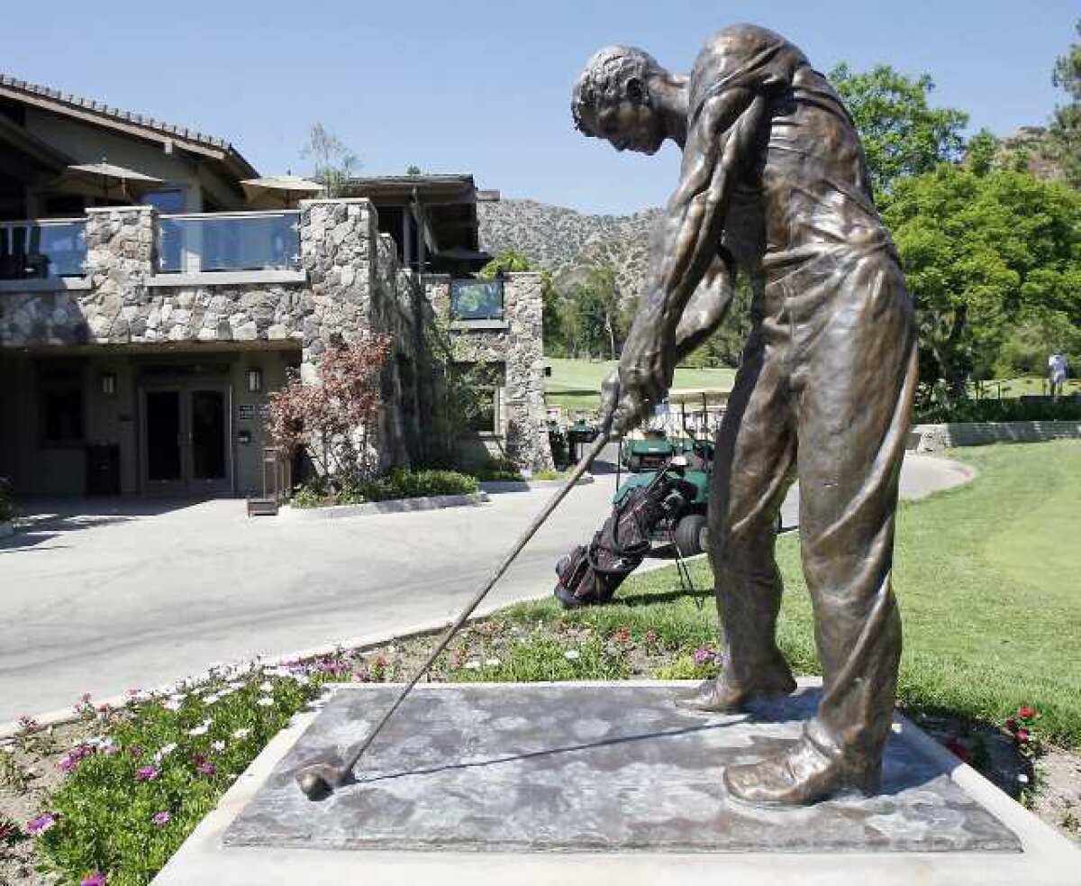 A statue of a golfer with the club house and pro shop behind it at DeBell Golf Club in Burbank. An oversight committee for the club implemented cost-cutting measures this week.