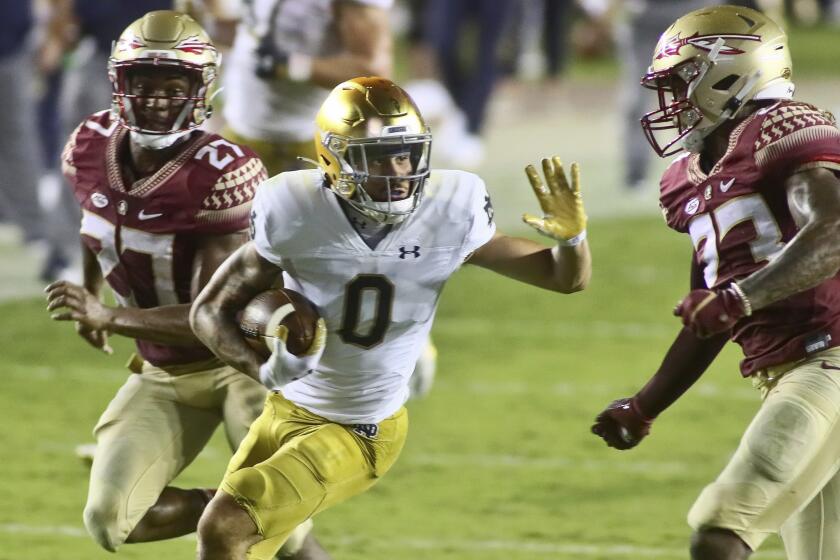 Notre Dame wide receiver Braden Lenzy (0) tries to stiff arm Florida State defensive back Sidney Williams.