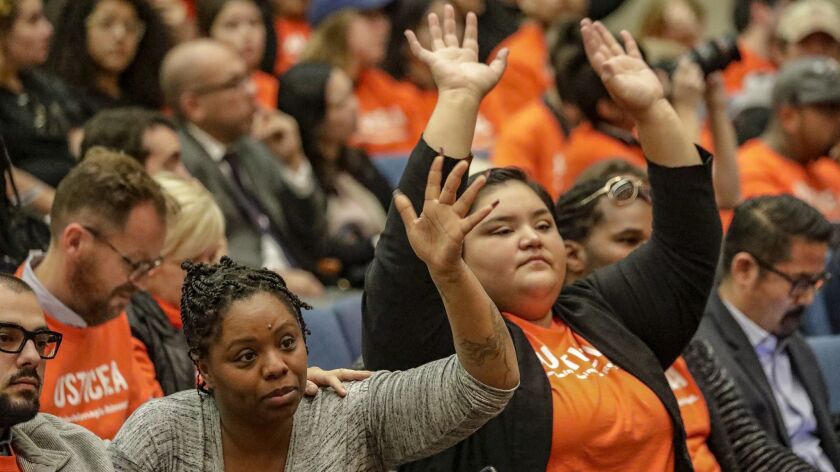 Community activists Patrisse Cullors, left, and Eunisses Hernandez raise their hands in agreement as they listen to a debate at the L.A. County Board of Supervisors over how to care for people with mental illness inside the county jails.