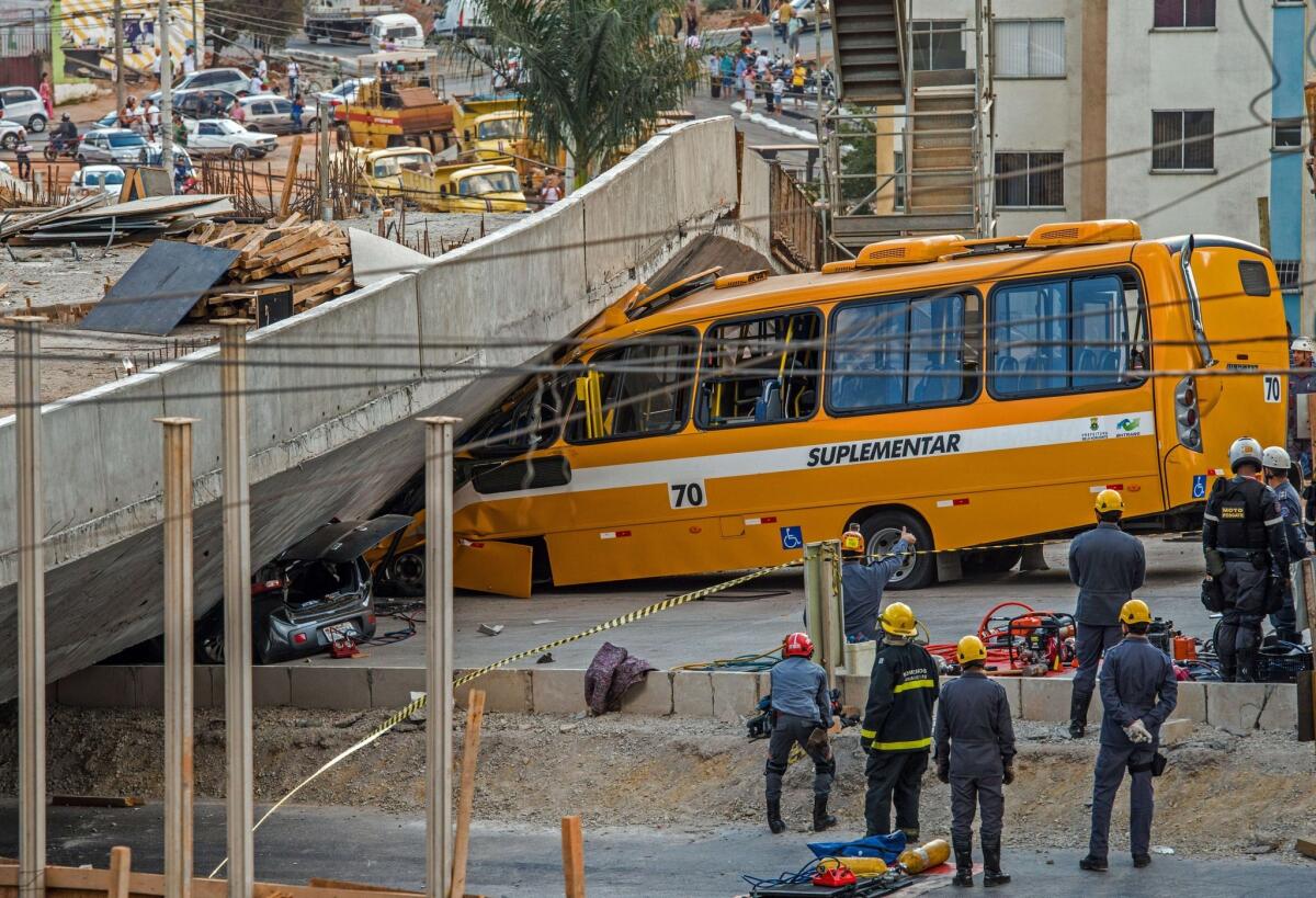 Firefighters and policemen work at the site where several vehicles were crushed by a viaduct that collapsed in Belo Horizonte, Brazil, on July 3, 2014. An unfinished overpass collapsed on vehicles in Brazil's southeastern World Cup city of Belo Horizonte on Thursday, killing at least two people and injuring 19, officials said.