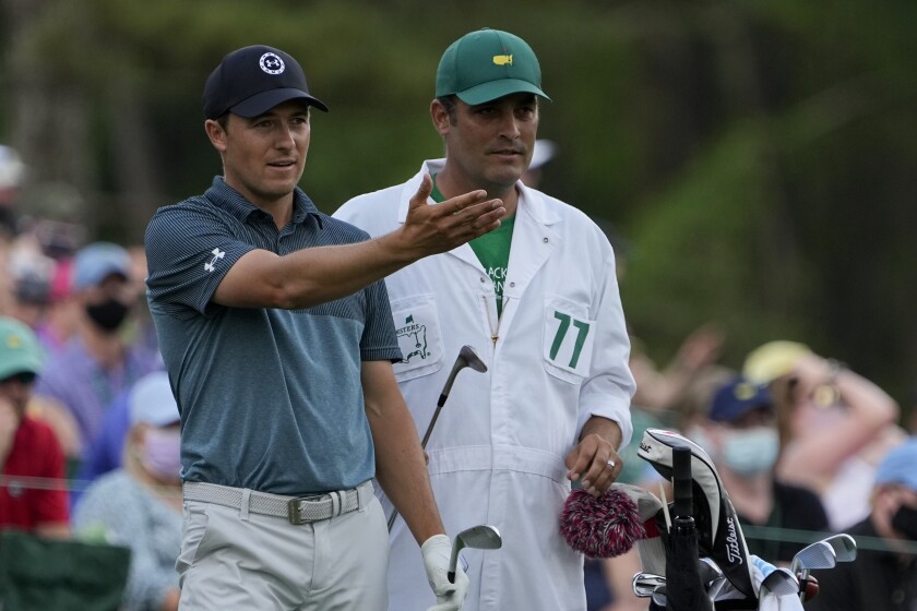 FILE - In this Sunday, April 11, 2021 file photo, Jordan Spieth discusses his tee shot with his caddie Michael Greller on the 12th hole during the final round of the Masters golf tournament, in Augusta, Ga. Spieth says he tested positive for the coronavirus three weeks ago. That led to a month break after the Masters. (AP Photo/David J. Phillip, File)