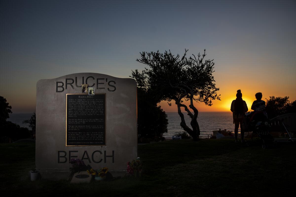 The sun sets behind a plaque memorializing a park adjacent to Bruce's Beach