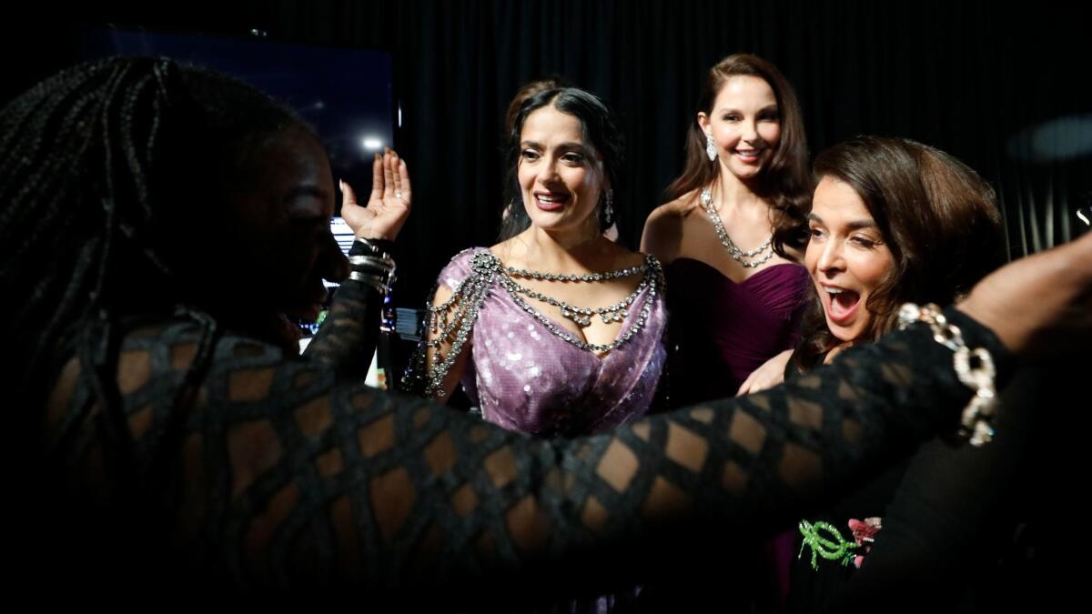 Activist and #MeToo pioneer Tarana Burke greets Salma Hayek, Ashley Judd, and Annabella Sciorra backstage at the 90th Academy Awards.