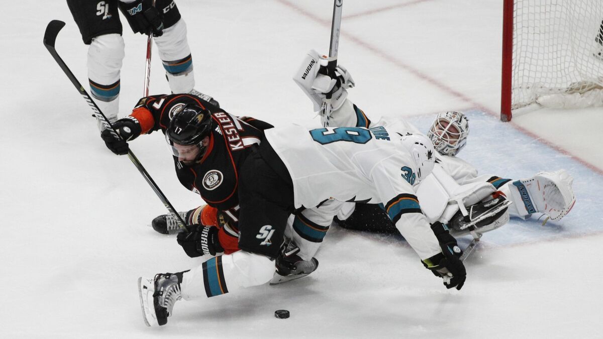 Ducks center Ryan Kesler can't get his stick on the puck as he is defended by San Jose's Logan Couture (39) in front of Sharks goaltender Martin Jones.