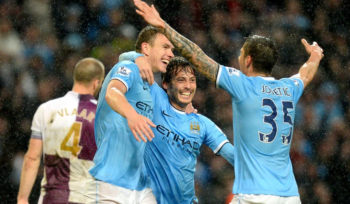 Manchester City striker Edin Dzeko, left, celebrates with teammates David Silva and Stevan Jovetic after scoring his second goal of the game against Aston Villa on Wednesday.