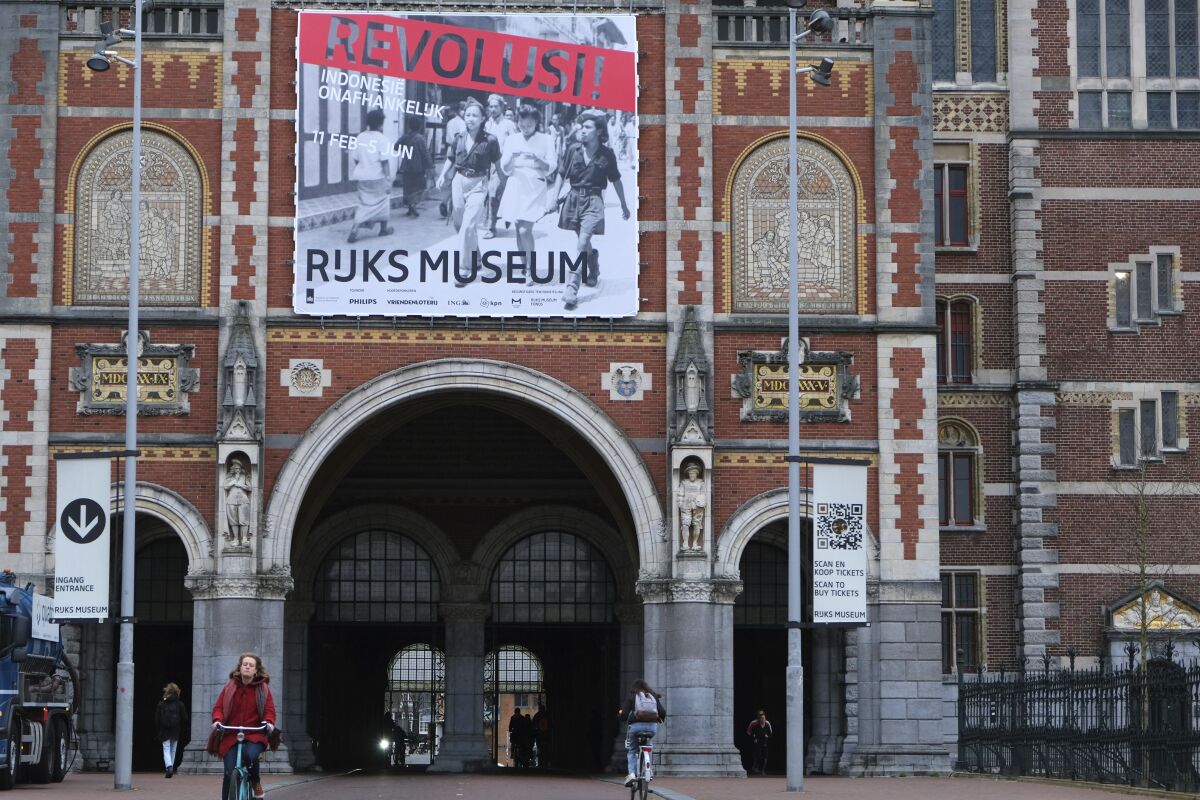 An external view of the National Museum in Amsterdam with a poster advertising the show, “Revolusi! Indonesia Independent”, Wednesday, Feb. 9, 2022. A new exhibition opens this week at the Dutch national museum that examines the violent birth of the Southeast Asian nation of Indonesia. The show, “Revolusi! Indonesia Independent” portrays the struggle for independence in the aftermath of World War II through the eyes of 23 witnesses. (AP photo/Mike Corder)